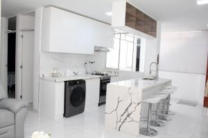 a white kitchen with a washing machine in it at Apartment in Ancon in Ancón +44 photos