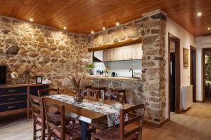 a kitchen and dining room with a stone wall at Ca la Inés in Corbera