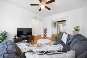 a living room with a couch and a ceiling fan at Spacious & Stylish 2BR Apartment Near Manhattan in Jersey City
