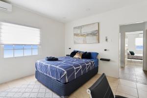 a bedroom with a blue bed and a mirror at Arcadian Place in Port-of-Spain