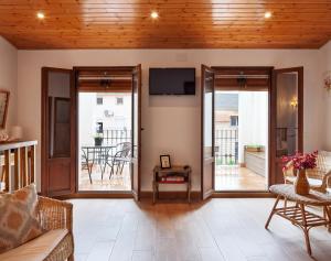 a living room with sliding glass doors and a television at Ca la Inés in Corbera