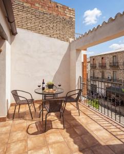 a patio with a table and chairs on a balcony at Ca la Inés in Corbera