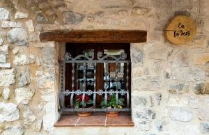 a window in a stone wall with bottles of wine at Ca la Inés in Corbera +20 photos