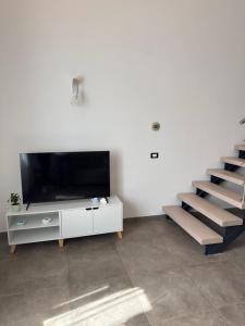 a living room with a flat screen tv and stairs at Le Cinque Terre da Pippo in La Spezia