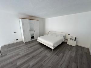 a white bedroom with a bed and a mirror at Le Cinque Terre da Pippo in La Spezia