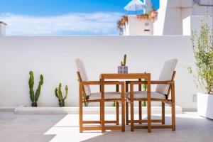 a table and chairs on a patio with a view of the ocean at Enea Dimora Procida in Procida
