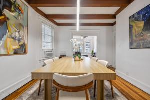 a dining room with a wooden table and chairs at Spacious & Stylish 2BR Apartment Near Manhattan in Jersey City