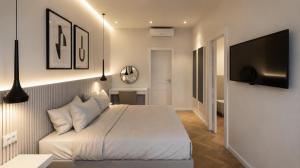 a bedroom with a bed and a flat screen tv at The Central Stay Cagliari in Cagliari
