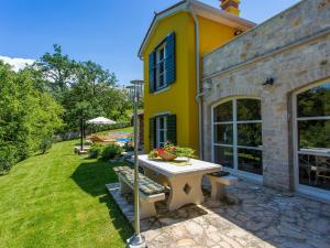 una casa amarilla con una mesa de picnic en el patio en Villa Splendida, en Poreč