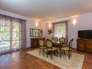Un comedor con mesa y sillas y un televisor. en Villa Splendida, en Poreč