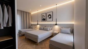a hotel room with two beds and a couch at The Central Stay Cagliari in Cagliari