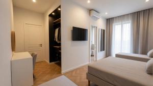 a bedroom with a bed and a tv on a wall at The Central Stay Cagliari in Cagliari +21 photos