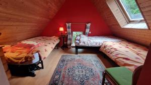 two beds in a room with red walls at Pen An Lan in Pleumeur-Bodou