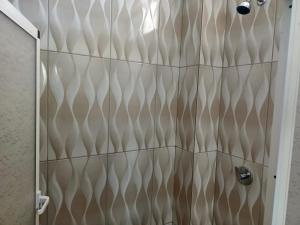 a shower stall with a brown and white pattern at Iguana Marina House in Puerto Villamil