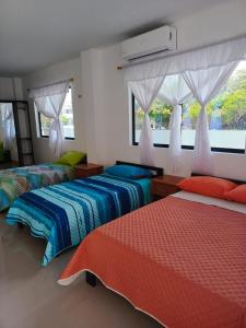a bedroom with two beds and a window at Iguana Marina House in Puerto Villamil