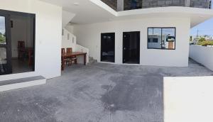 an empty living room with a table and windows at Iguana Marina House in Puerto Villamil