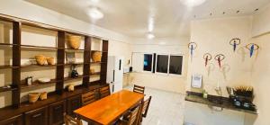 a dining room with a table and a kitchen with scissors on the wall at Tribus Hostel in Manaus +22 photos