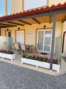 a patio with flowers and a table and chairs at Blue Port Beach House in Rafina