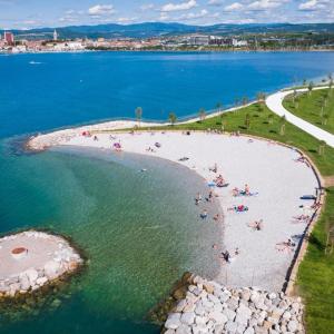 a group of people on a beach in the water at Apartma Sparkle in Koper