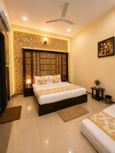 a bedroom with two beds and a stone wall at Hotel Crystal Blues in Mathura