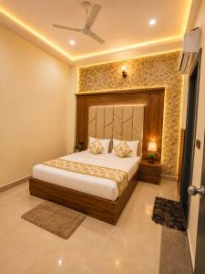 a bedroom with a bed and a stone wall at Hotel Crystal Blues in Mathura