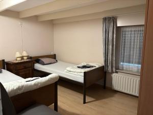 a small room with two beds and a window at Vakantie-woning in Sint Kruis