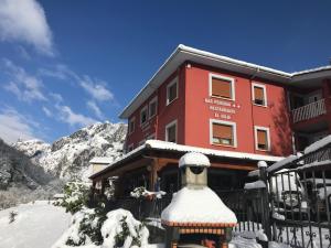 a building with a snow man in front of it at El Duje in Tielve
