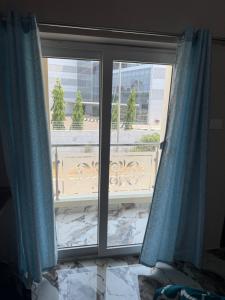 a window with blue curtains in a room at DRK Luxury Stays in Siruseri