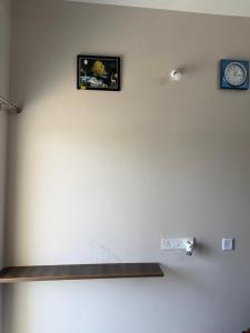 a wall with two pictures and a clock on it at DRK Luxury Stays in Siruseri