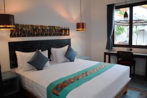 una camera da letto con un grande letto bianco con cuscini di Jali Resort - Gili Trawangan a Gili Trawangan