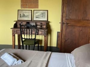 a bedroom with a desk with a chair and a bed at Dimora 45, Contemporary Apartments in a Historic Building, Valdichiana, Tuscany in Sinalunga