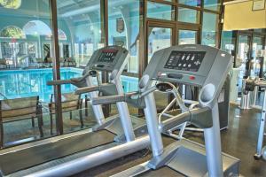 a gym with two treadmills next to a swimming pool at Kingsgate Resort 2BR Apartment in Williamsburg