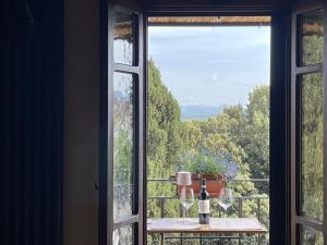 a window with a view of a table with a bottle of wine at Dimora 45, Contemporary Apartments in a Historic Building, Valdichiana, Tuscany in Sinalunga