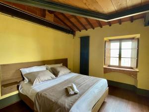 a bedroom with a bed with a teddy bear on it at Dimora 45, Contemporary Apartments in a Historic Building, Valdichiana, Tuscany in Sinalunga