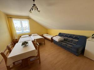 a living room with a blue couch and tables at Villa Alexandria in Darłówko