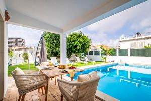 a patio with a table and chairs next to a swimming pool at The Royal Guesthouse in Faro