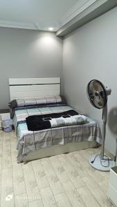 a bedroom with a bed with a fan and a lamp at Ashraf Residential Complex in Luxor