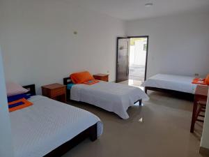 a room with three beds and a mirror at Iguana Marina House in Puerto Villamil