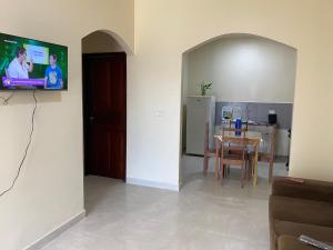 a living room with a table and a tv on a wall at Maresia in Cacoal
