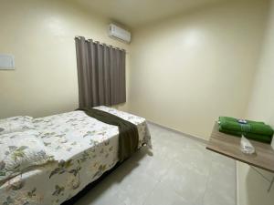 a small bedroom with a bed and a table at Maresia in Cacoal