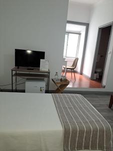 a living room with a bed and a television at Jomafreitas in Ponta Delgada