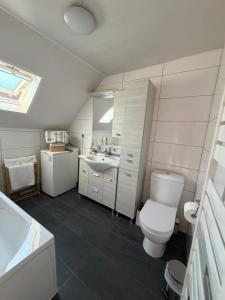 a white bathroom with a toilet and a sink at séjour en Alsace in Ingersheim +29 photos