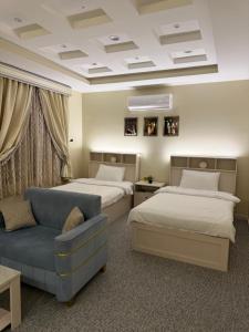 a hotel room with two beds and a couch at مسكن الفخامة in Taif