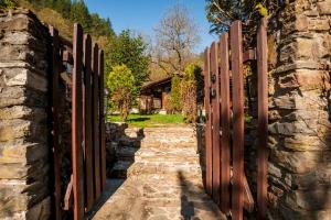 a gate in a stone wall with a pathway at Вила Соколето in Sokolovtsi