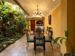 a dining room with a table and chairs at Hotel 1915 INN & SUITES in Alajuela