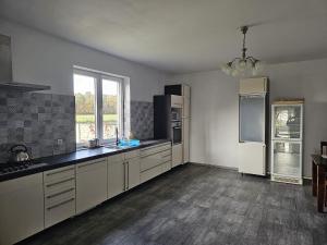 a large kitchen with white cabinets and appliances at Agroturystyka Pod Dębem in Czyżówek