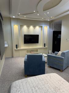 a living room with a flat screen tv and a couch at مسكن الفخامة in Taif