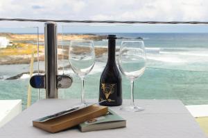 a bottle of wine and two wine glasses on a table at Caleta Blue House - MacaronesiaHomes in Caleta de Caballo +18 photos