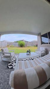 a group of chairs and a table on a patio at Canaan Oasis in Pimpama
