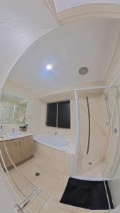 a white bathroom with a tub and a sink at Canaan Oasis in Pimpama +22 photos